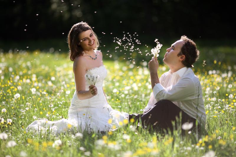 Agata and Roman blowing flower seeds to the wind.