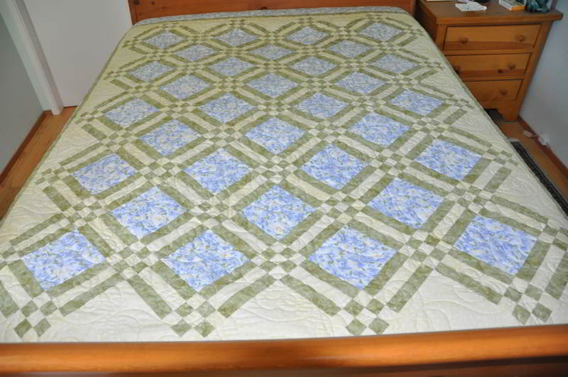 A photo of the quilt on a bed.