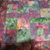 A modernistic looking lap quilt, City Slicker, in purple and green batiks