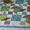 Scrappy Windmills quilt in blues, greens & browns. Kit from Village Quilts in Lethbridge.
